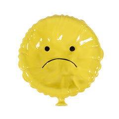 Svuotatasche Sad Balloon giallo in ceramica smaltata lucida, vista frontale del palloncino sgonfio con espressione triste, complemento d'arredo di design.